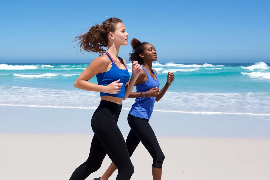 Two ladies jogging along the beach