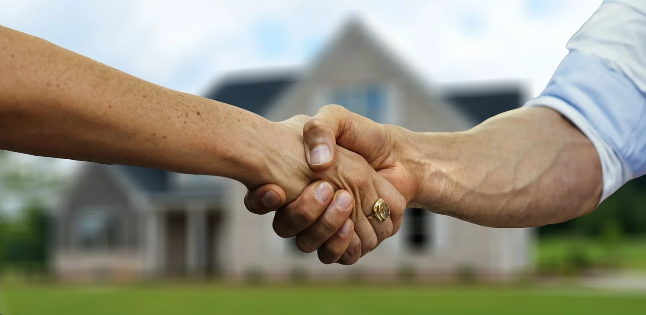 Handshake with house in background