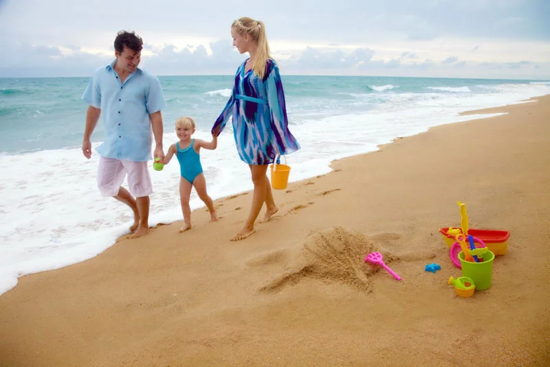 Couple with small child walking along the beach