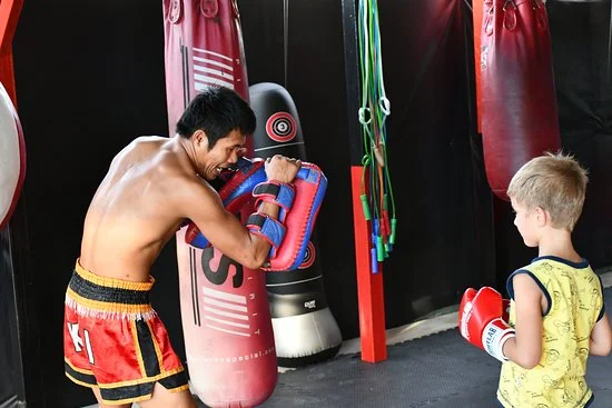 Muay Thai trainer with youg boy