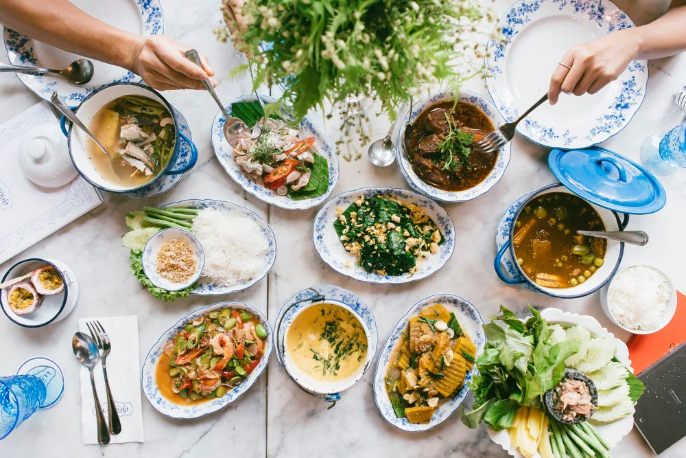 A table with many Thai dishes laid out