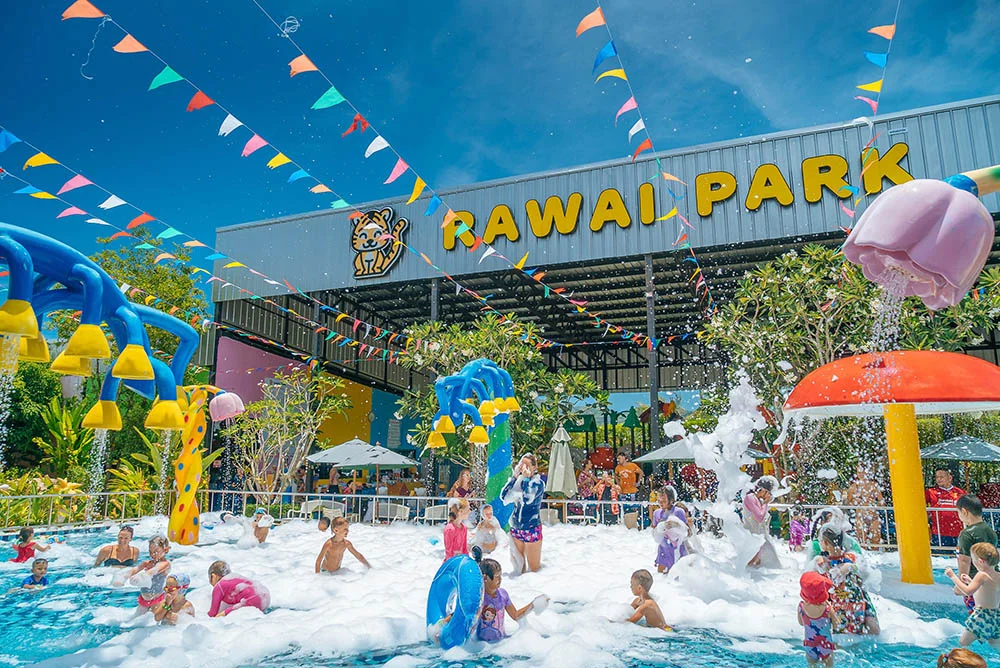 Young kids playing in foam in a shallow pool at Rawai Park