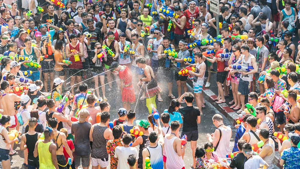 A crowd shoot water pistols at a few people in the middle